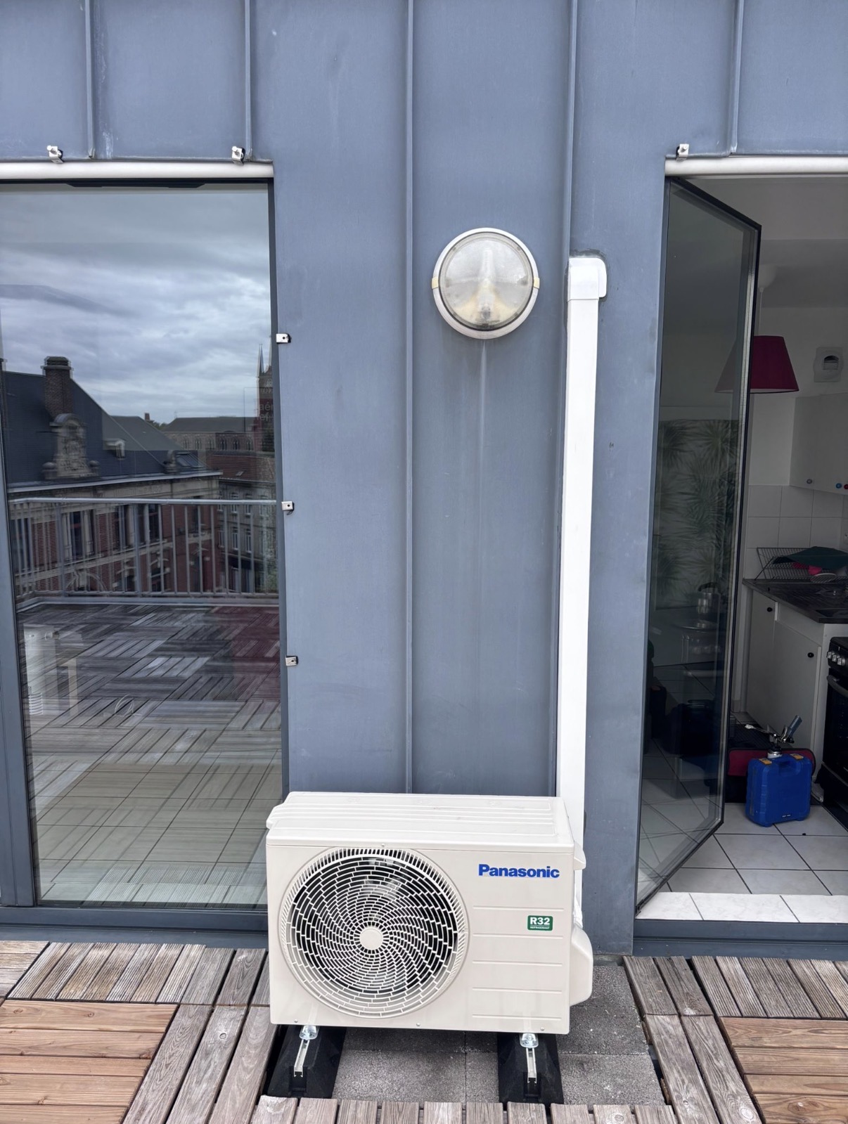Unité extérieure Panasonic R32 posée sur plots sur la terrasse