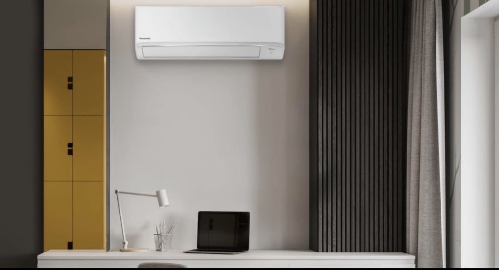 Unité intérieure de climatisation mono-split Panasonic blanche, installée dans un bureau moderne