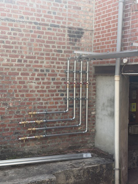 Réseau hydraulique principal en diamètre 42 avec vannes sur mur en briques — installation collective HFE