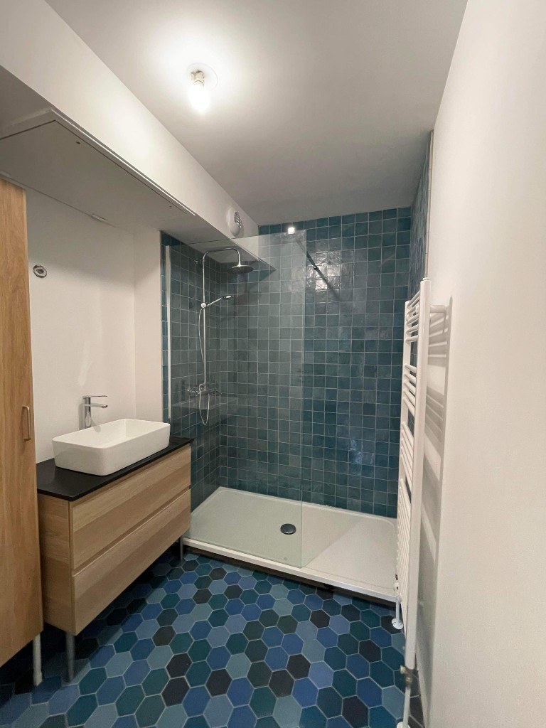 Salle de bain moderne avec douche zellige bleu canard et sol mosaïque hexagonale — HFE